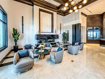 a living room with a large window and chandelier