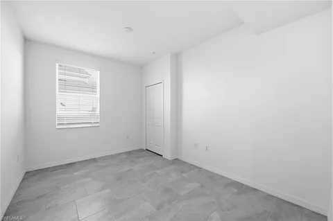 a kitchen with white cabinets appliances and a window