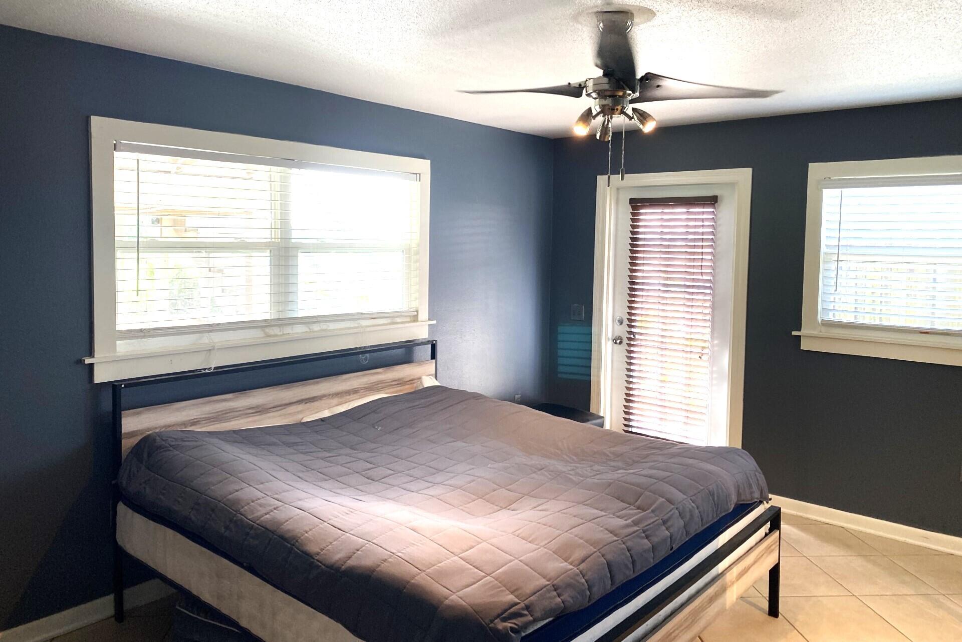 725 Mallard Road Cocoa, FL 32926 - Photo 16 of 37 a bedroom with a bed and a chandelier