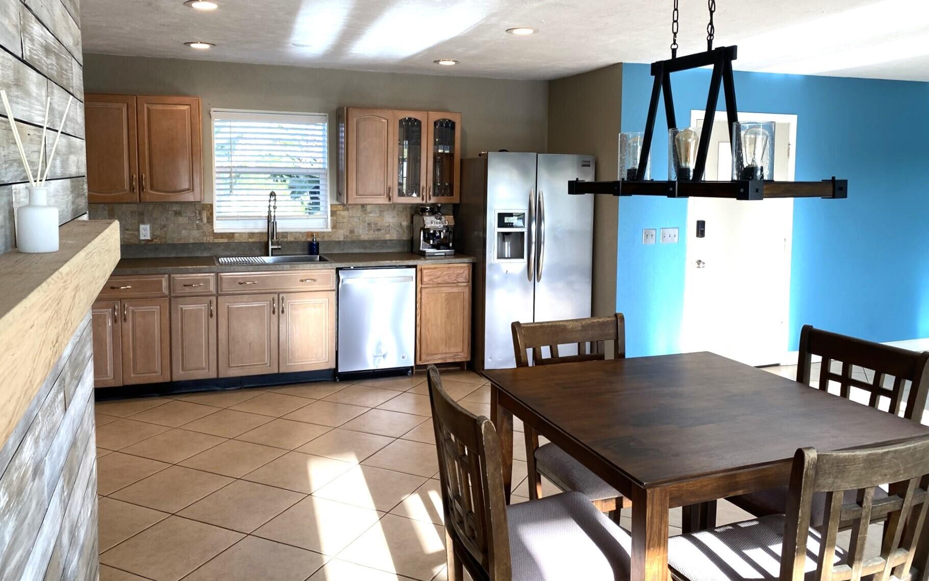 725 Mallard Road Cocoa, FL 32926 - Photo 19 of 37 a kitchen with stainless steel appliances granite countertop a stove a refrigerator a sink a dining table and chairs