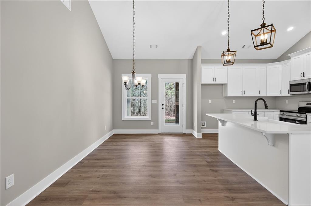 423 Relay Road Silver Creek, GA 30173 - Photo 21 of 48 a kitchen with stainless steel appliances a kitchen island hardwood floor sink stove and wooden floor