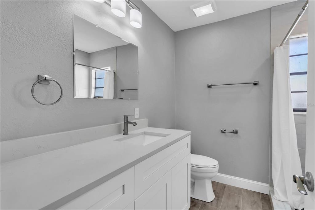 5925 Seaside Drive New Port Richey, FL 34652 - Photo 32 of 55 a bathroom with a granite countertop sink a toilet and a mirror
