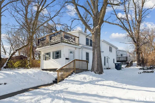 a front view of a house with a yard covered with snow