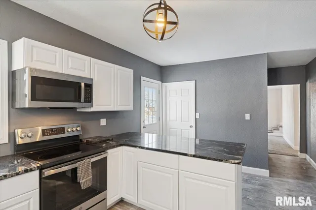 a kitchen with stainless steel appliances granite countertop a stove and a microwave