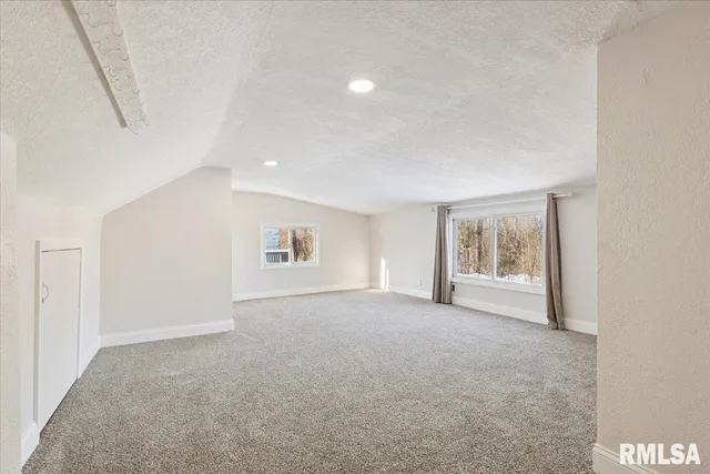 an empty room with windows and closet