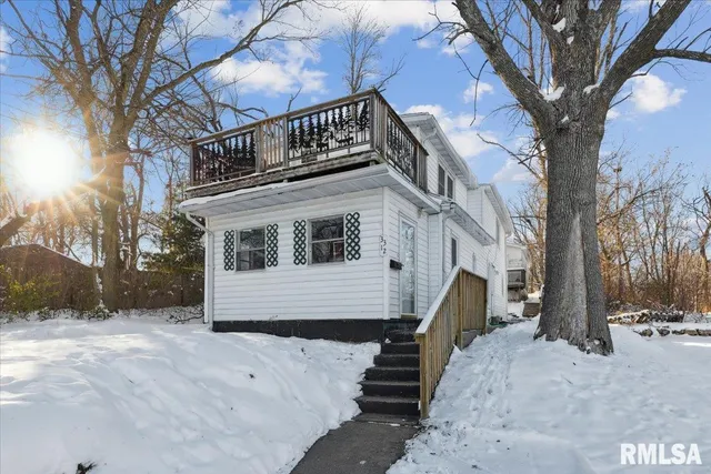 a front view of a house with a yard covered in snow