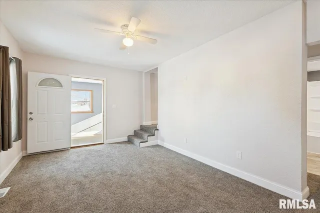 an empty room with closet and a ceiling fan