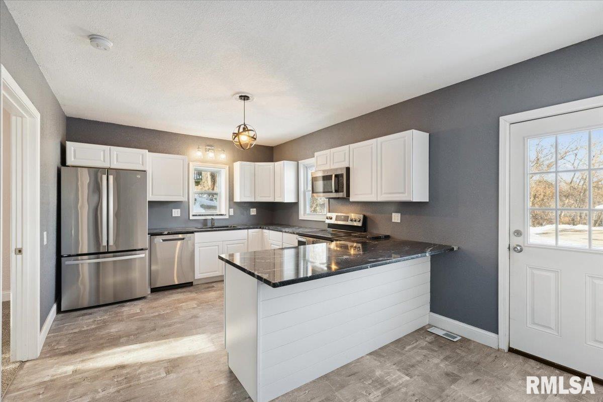 3312 Garfield Street Clinton, IA 52732 - Photo 8 of 31 a kitchen with stainless steel appliances granite countertop a refrigerator a sink dishwasher a stove and white countertops with wooden floor