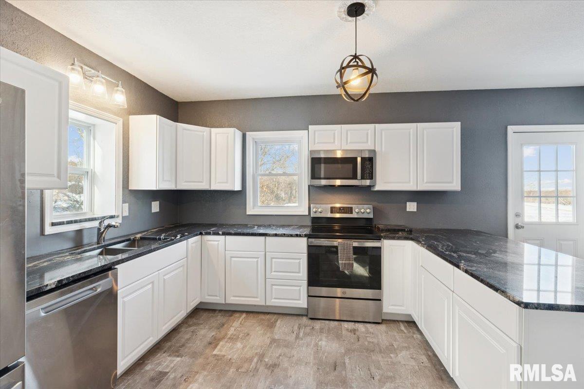 3312 Garfield Street Clinton, IA 52732 - Photo 9 of 31 a kitchen with stainless steel appliances granite countertop a sink a stove a microwave and cabinets