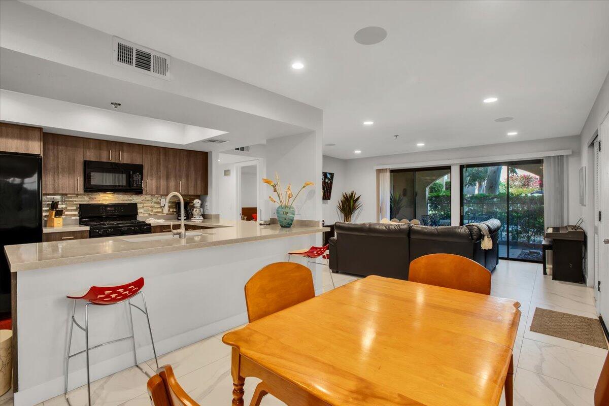 200 East Racquet Club Road, Unit 31 Palm Springs, CA 92262 - Photo 12 of 49 a view of a dining room with furniture a kitchen and chandelier