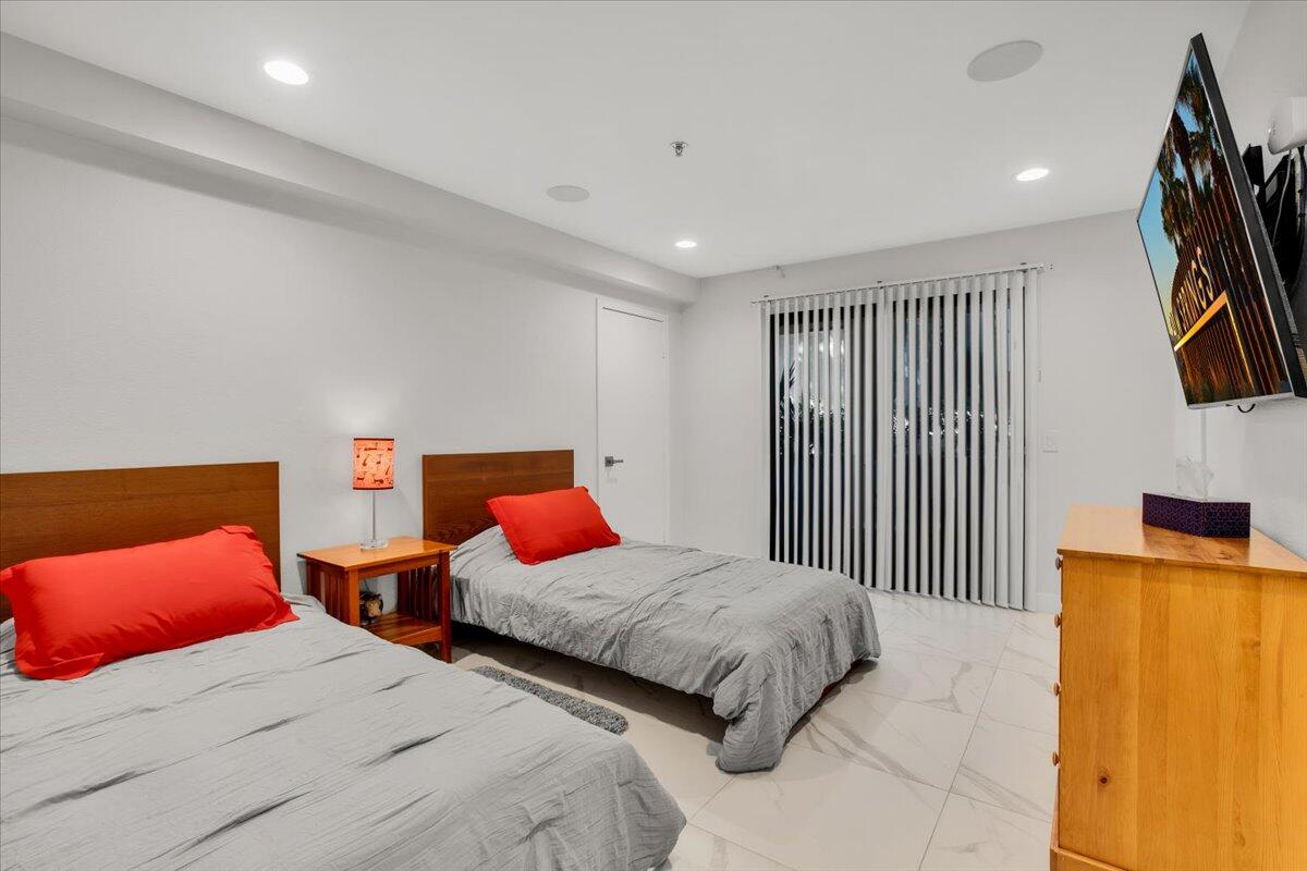 200 East Racquet Club Road, Unit 31 Palm Springs, CA 92262 - Photo 17 of 49 a bedroom with two beds and a night stand