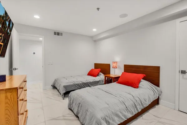 a bedroom with two beds and a lamp