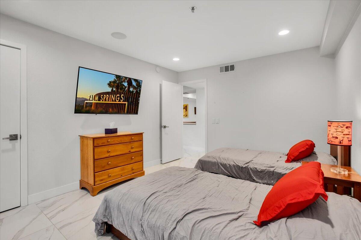 200 East Racquet Club Road, Unit 31 Palm Springs, CA 92262 - Photo 19 of 49 a bedroom with a bed and a flat screen tv
