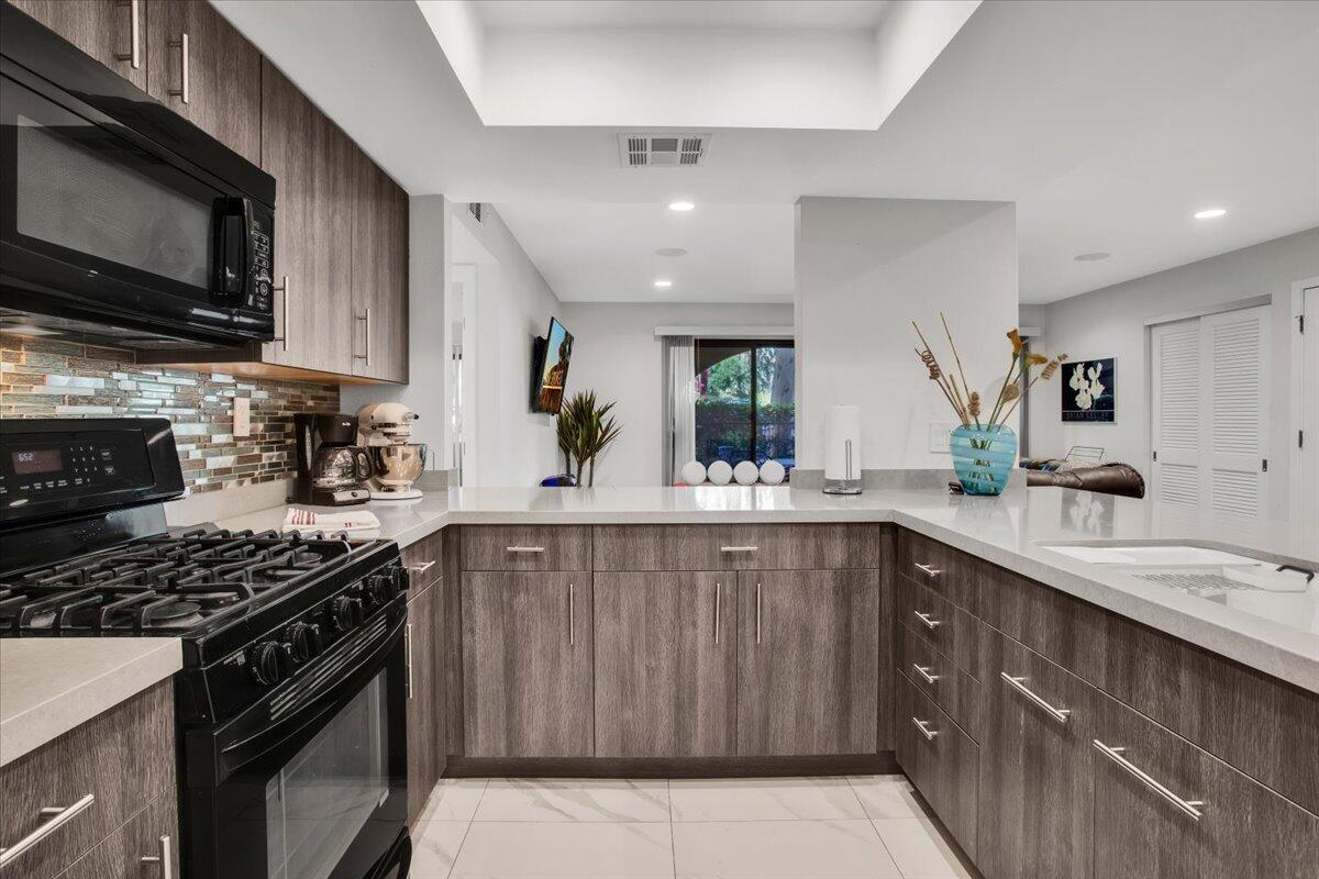 200 East Racquet Club Road, Unit 31 Palm Springs, CA 92262 - Photo 2 of 49 a kitchen with stainless steel appliances a sink stove and cabinets