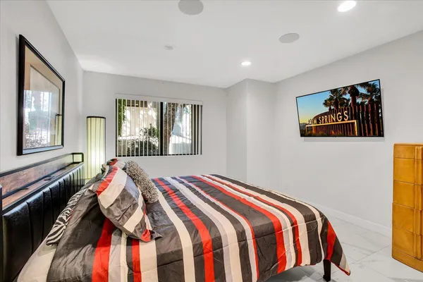 a bedroom with a bed and a painting on the wall