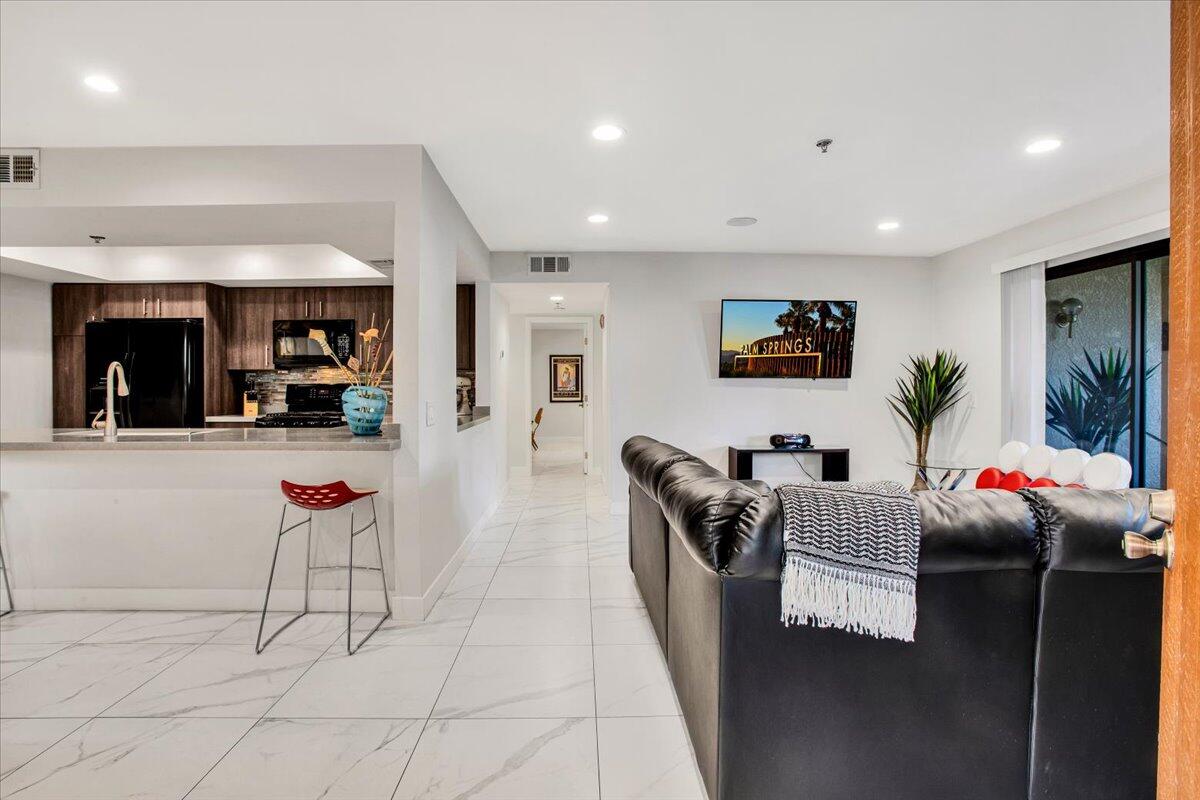 200 East Racquet Club Road, Unit 31 Palm Springs, CA 92262 - Photo 3 of 49 a living room with furniture and a flat screen tv