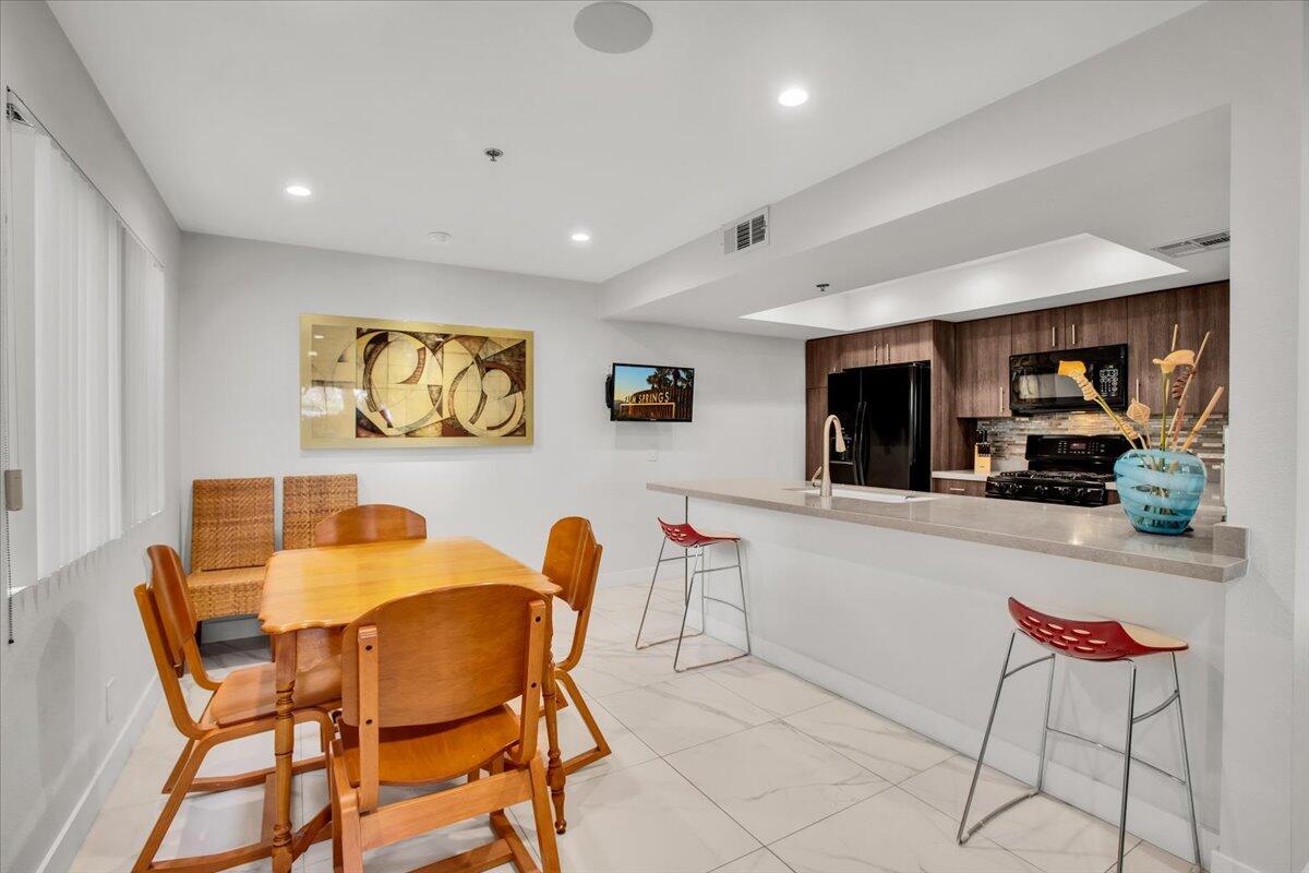 200 East Racquet Club Road, Unit 31 Palm Springs, CA 92262 - Photo 10 of 49 a dining room with furniture and window