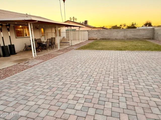 a backyard of a house with table and chairs