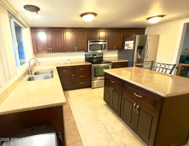 a kitchen with a sink appliances and cabinets