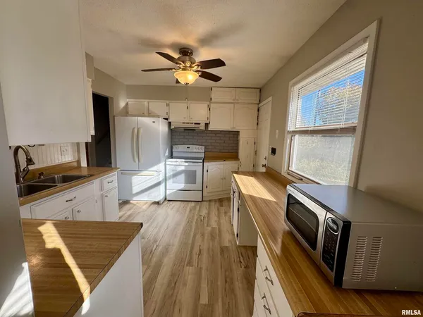 a kitchen with granite countertop stainless steel appliances a sink stove top oven and cabinets