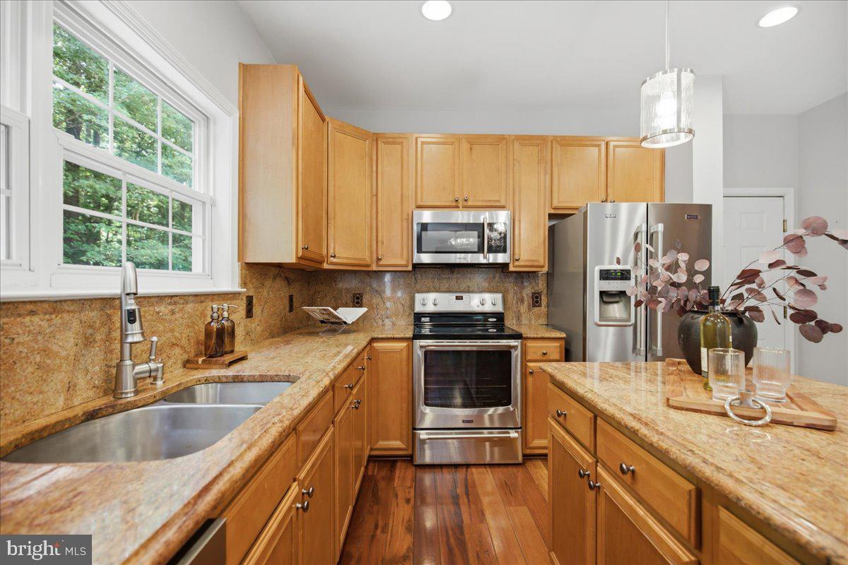 2424 Springbrook Court Huntingtown, MD 20639 - Photo 36 of 103 a kitchen with stainless steel appliances a sink dishwasher a stove top oven a refrigerator with wooden floor and cabinets