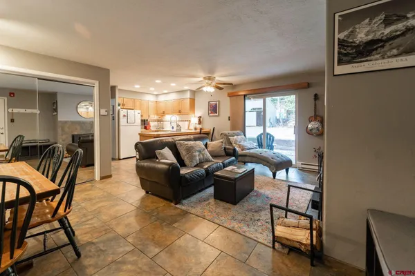a living room with furniture a chandelier and a dining table