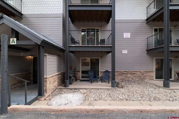 a front view of a house with barbeque grill and seating space