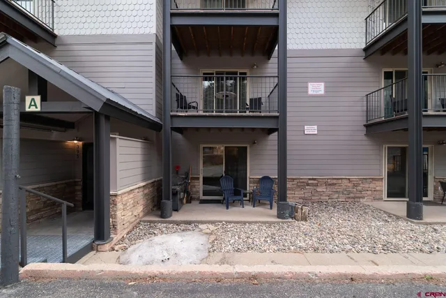 a front view of a house with barbeque grill and seating space