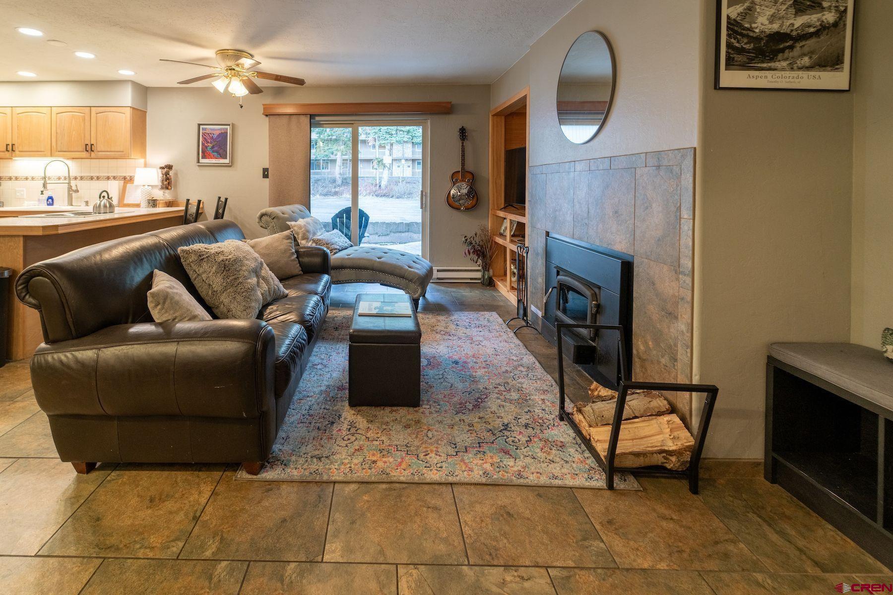 395 Sheol Street, Unit 26 Durango, CO 81301 - Photo 6 of 30 a living room with furniture a fireplace and a flat screen tv