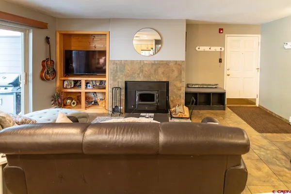 a living room with a couch a fireplace and a flat screen tv