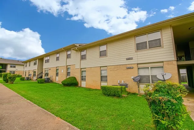 a view of a white house with a big yard and large trees