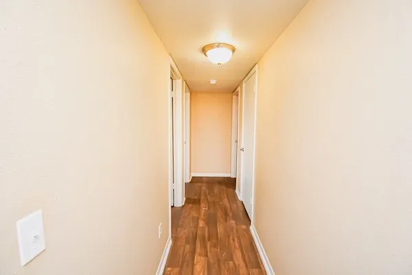a view of a hallway with wooden floor