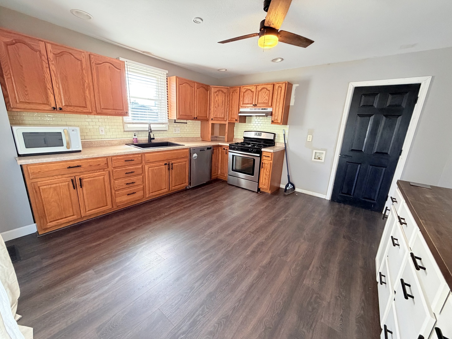 608 West Cedar Street Le Roy, IL 61752 - Photo 4 of 17 a kitchen with stainless steel appliances wooden floors and a window