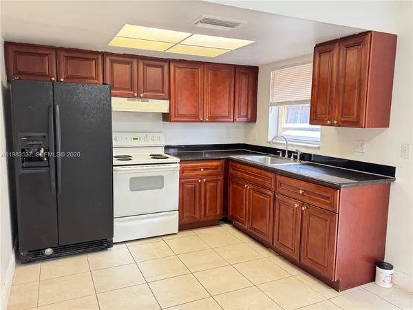 a kitchen with stainless steel appliances granite countertop a refrigerator stove and sink
