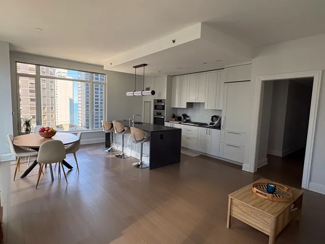 a living room with furniture a dining table and a window
