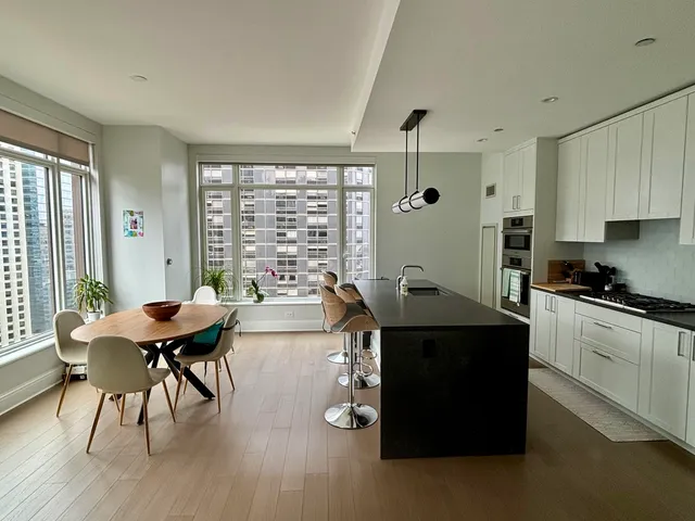 a living room with furniture a wooden floor and a large window