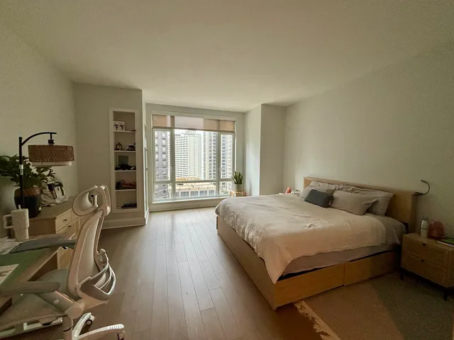 a bedroom with a bed and a wooden floor