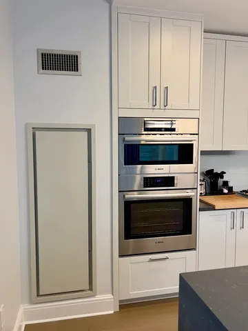 a kitchen with granite countertop white cabinets and stainless steel appliances