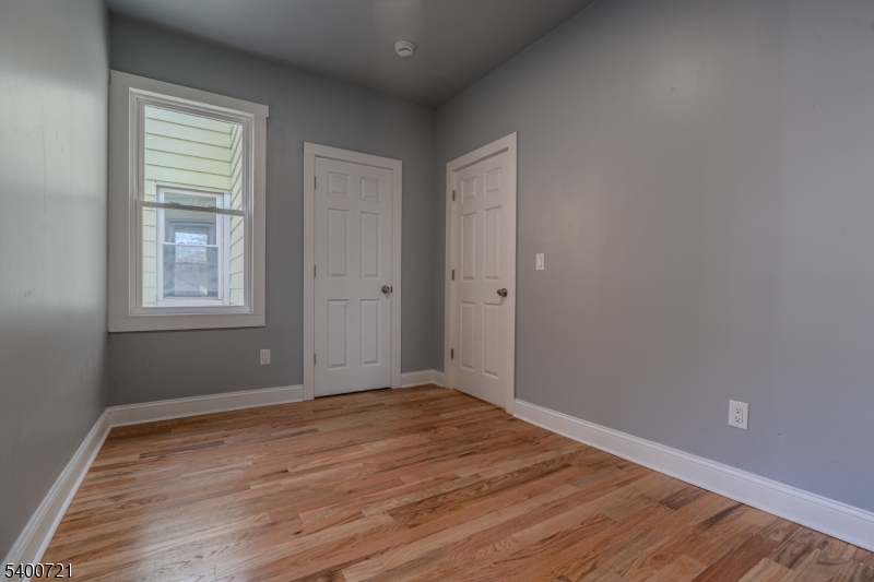 882 South 14th Street, Unit 3 Newark, NJ 07108 - Photo 7 of 20 an empty room with wooden floor and windows