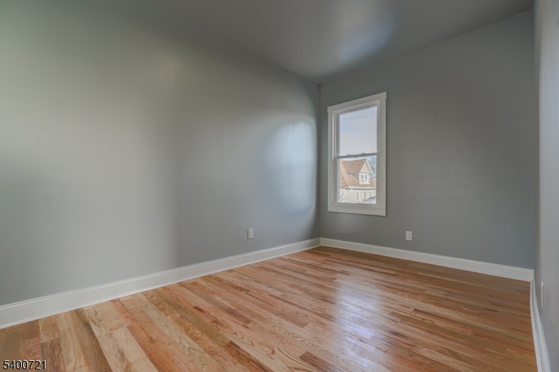 882 South 14th Street, Unit 3 Newark, NJ 07108 - Photo 9 of 20 a view of an empty room with wooden floor and a window