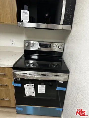 a stove top oven sitting inside of a kitchen
