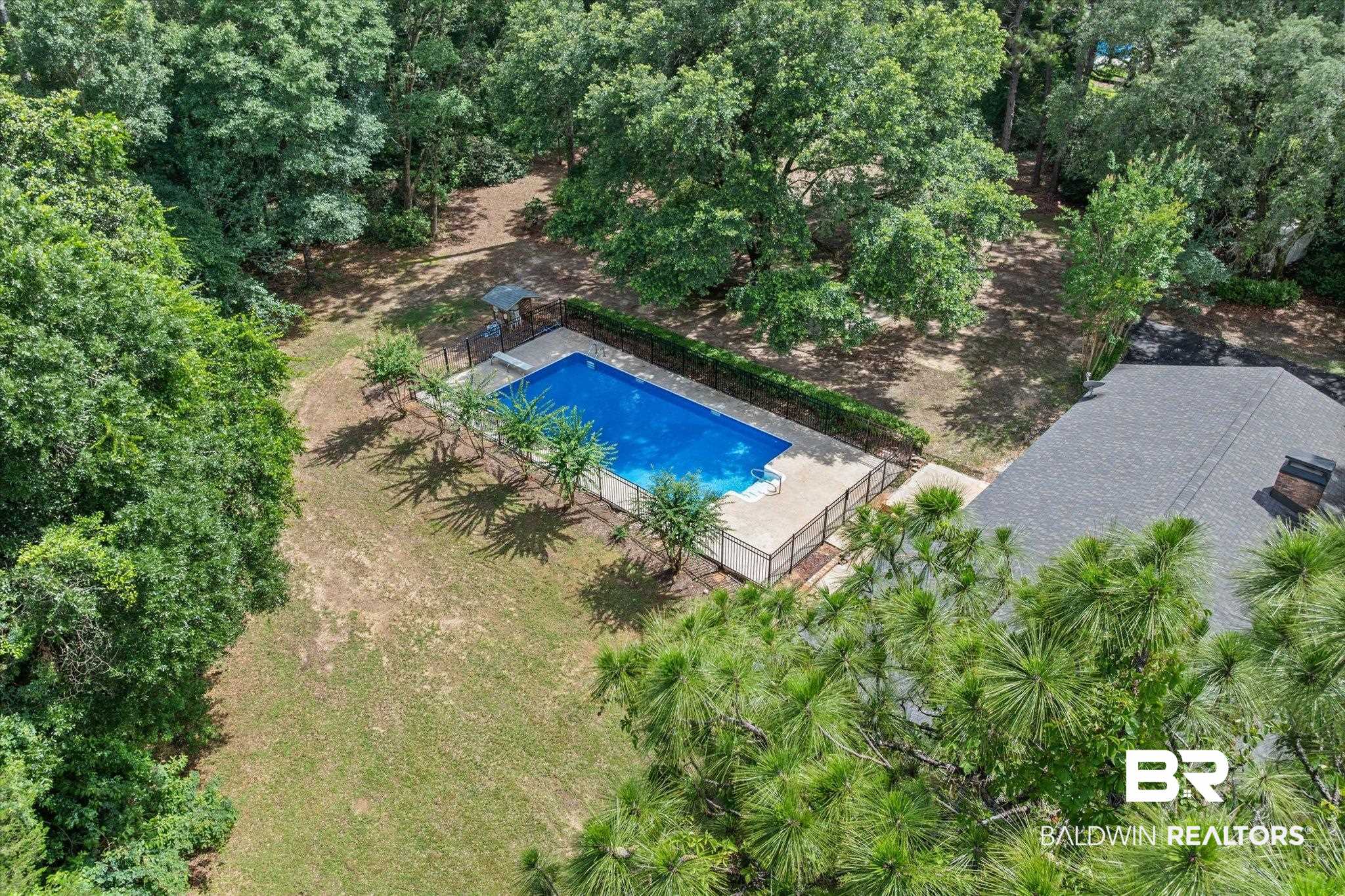 8301 Fordham Road Mobile, AL 36619 - Photo 49 of 57 In-ground rectangular swimming pool surrounded by a concrete patio and black metal fencing