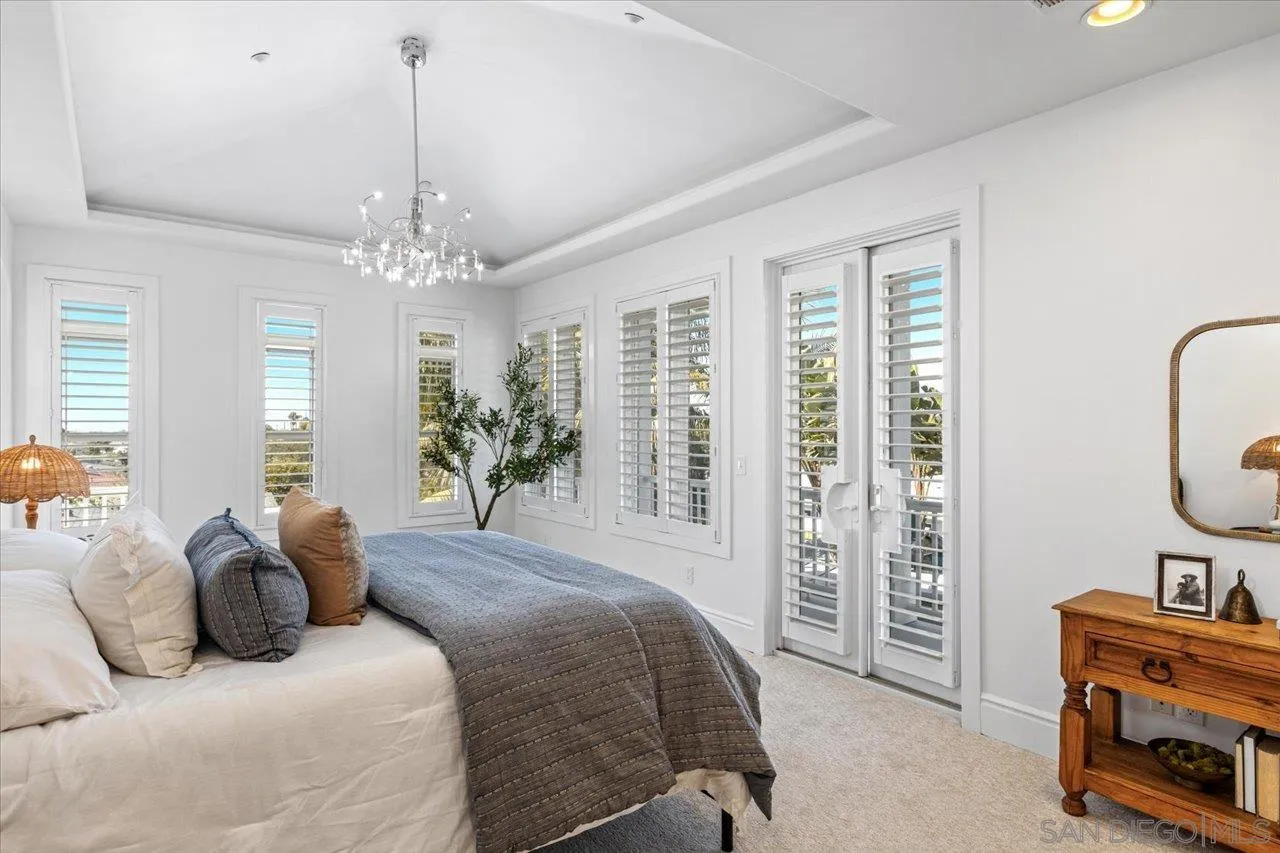 1066 Melba Road Encinitas, CA 92024 - Photo 11 of 54 a spacious bedroom with a bed and a chandelier