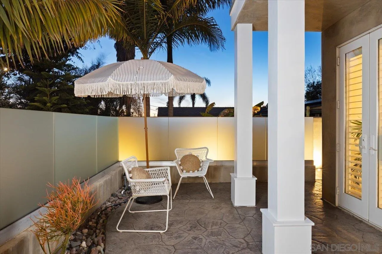 1066 Melba Road Encinitas, CA 92024 - Photo 29 of 54 a patio table and chairs under an umbrella with wooden fence