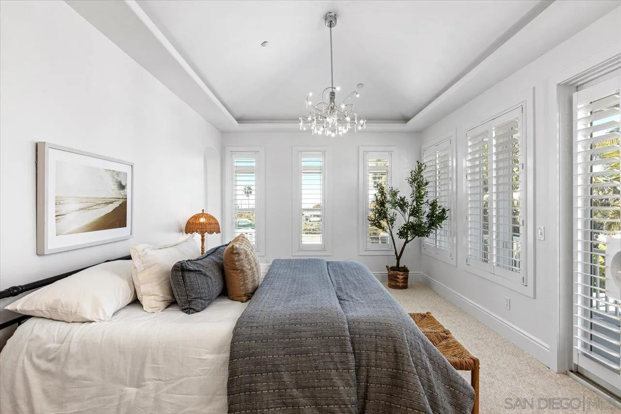 1066 Melba Road Encinitas, CA 92024 - Photo 37 of 54 a bedroom with a large bed and a chandelier