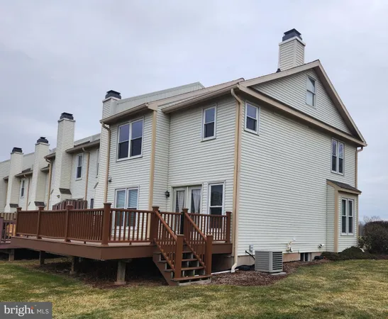 a view of a house with wooden deck and swimming pool