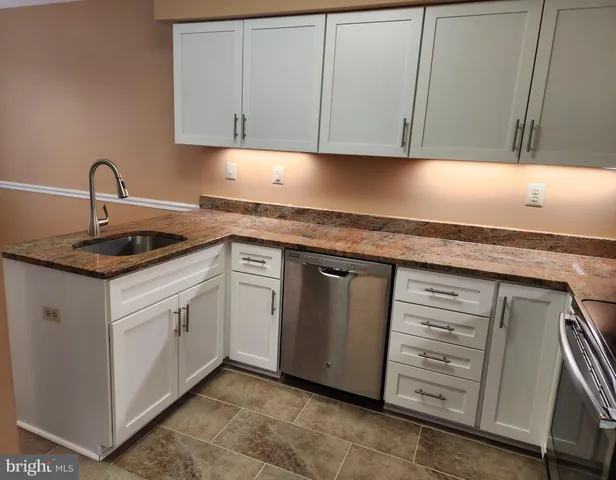 a kitchen with granite countertop a sink and dishwasher