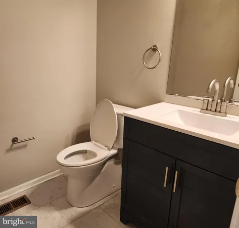 a bathroom with a toilet sink vanity and mirror