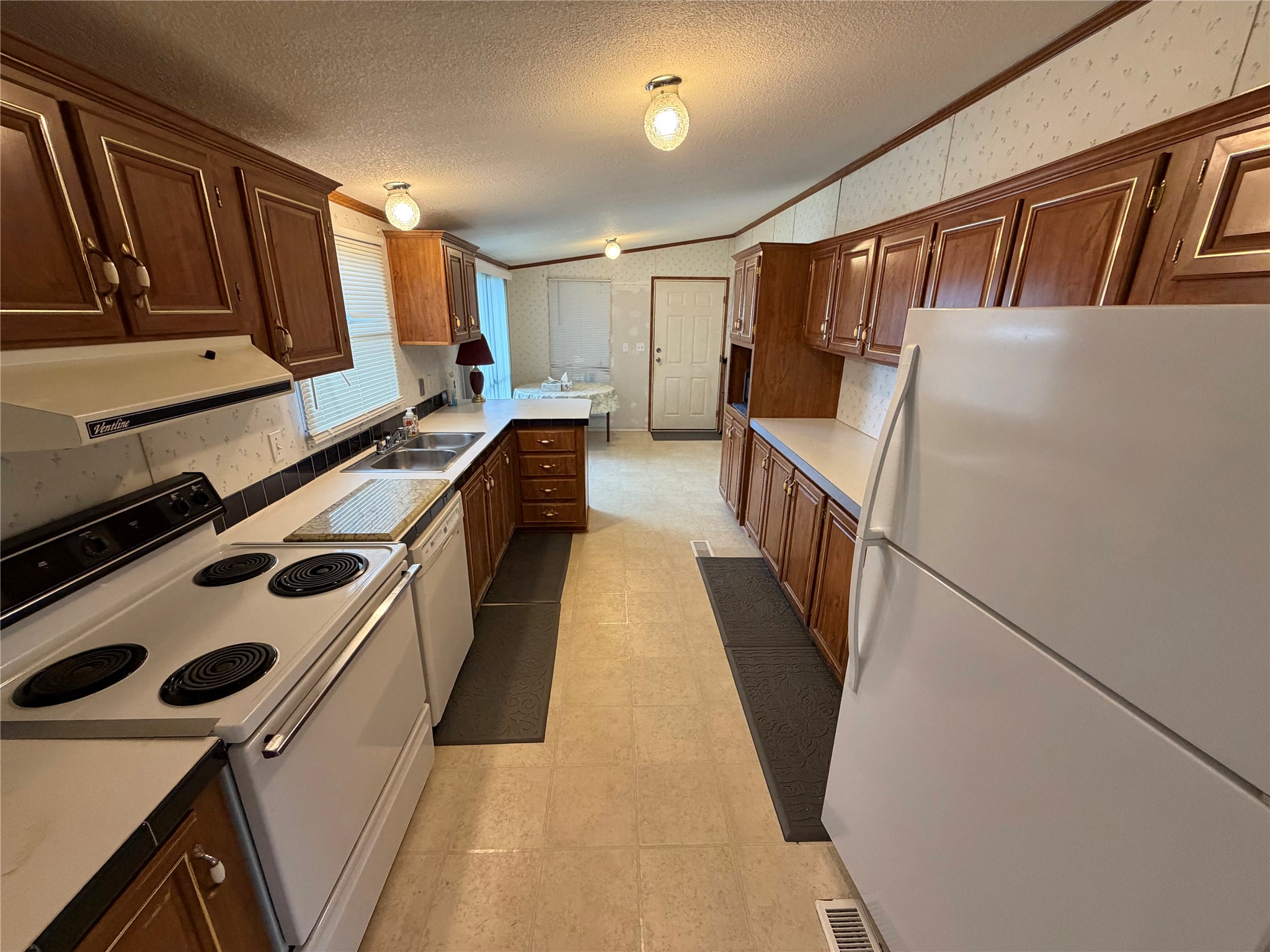 153 Prairie Lea Drive Angleton, TX 77515 - Photo 11 of 30 a kitchen with sink a refrigerator and cabinets