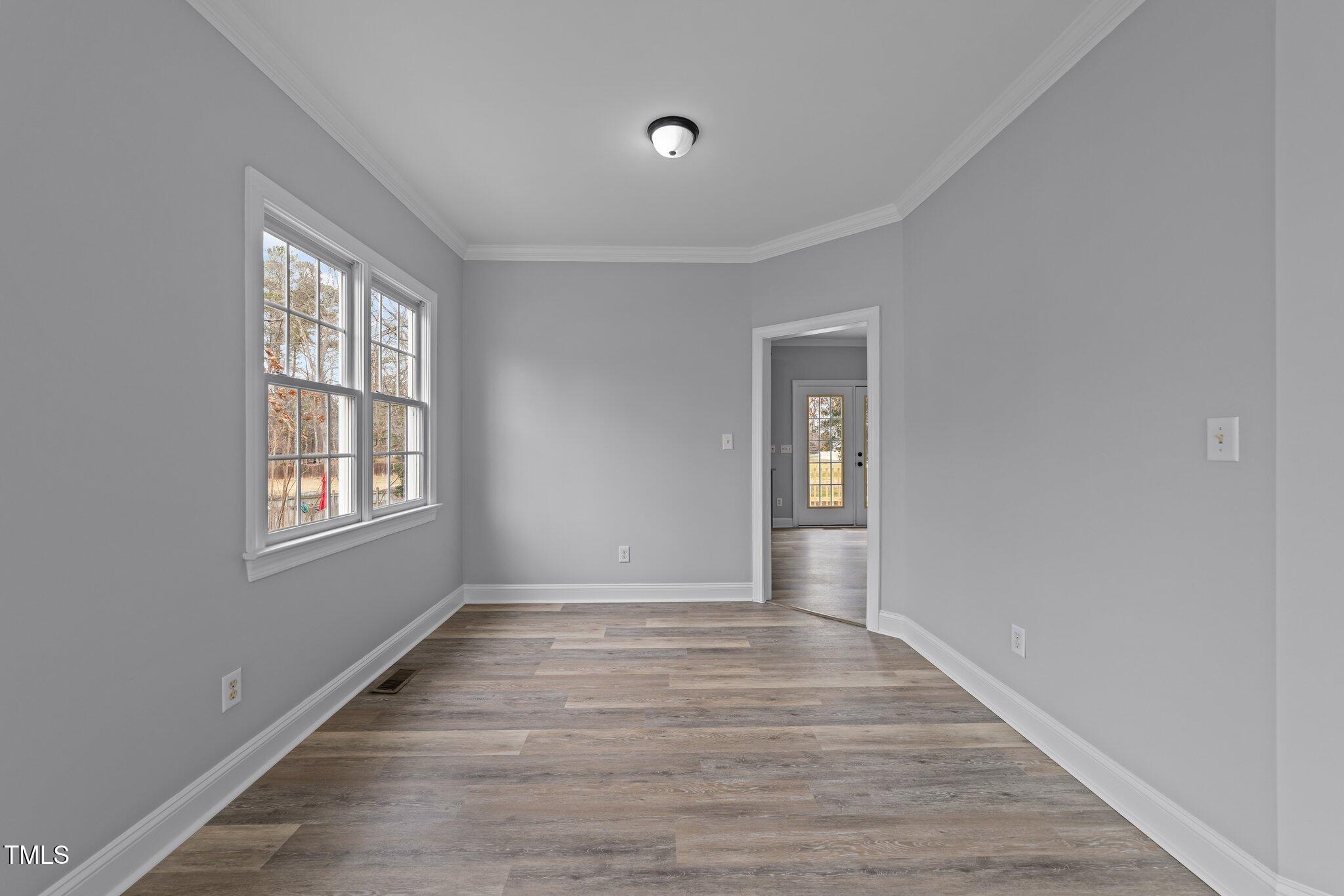 3525 La Costa Way Raleigh, NC 27610 - Photo 8 of 45 a view of an empty room with wooden floor and a window